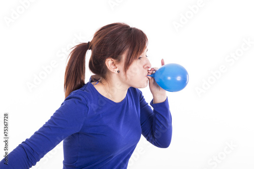 Portrait of young woman blowing balloon