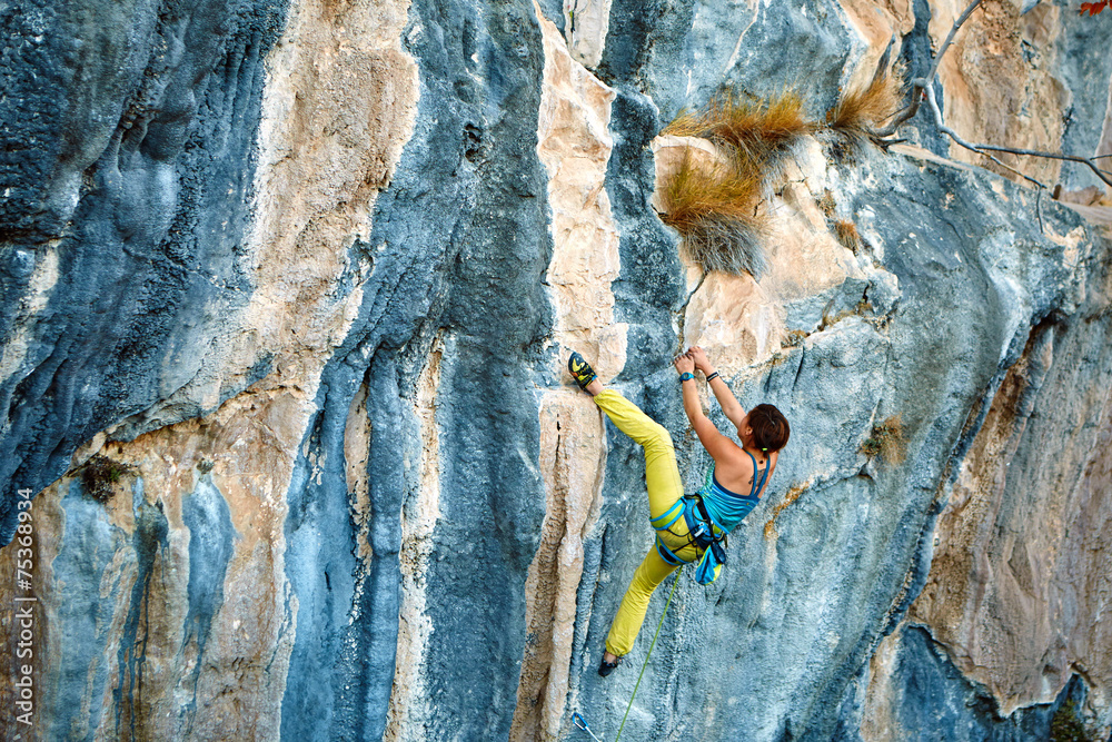 Rock climber climbing up a cliff Rock climber climbing up a cliff