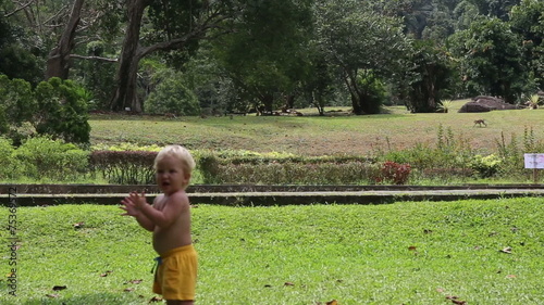 small blonde baby girl claps his hands and goes toward running