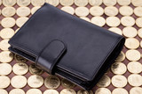 Black leather wallet on golden coins