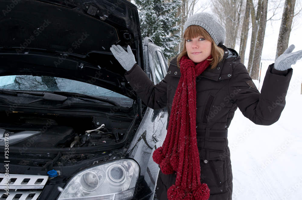 Fototapeta premium Junge Frau mit Autopanne im Winter