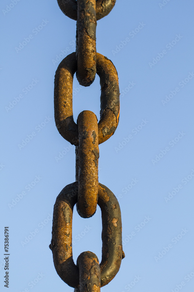 thick rusty chain on a blue sky background thick rusty chain on a blue sky background
