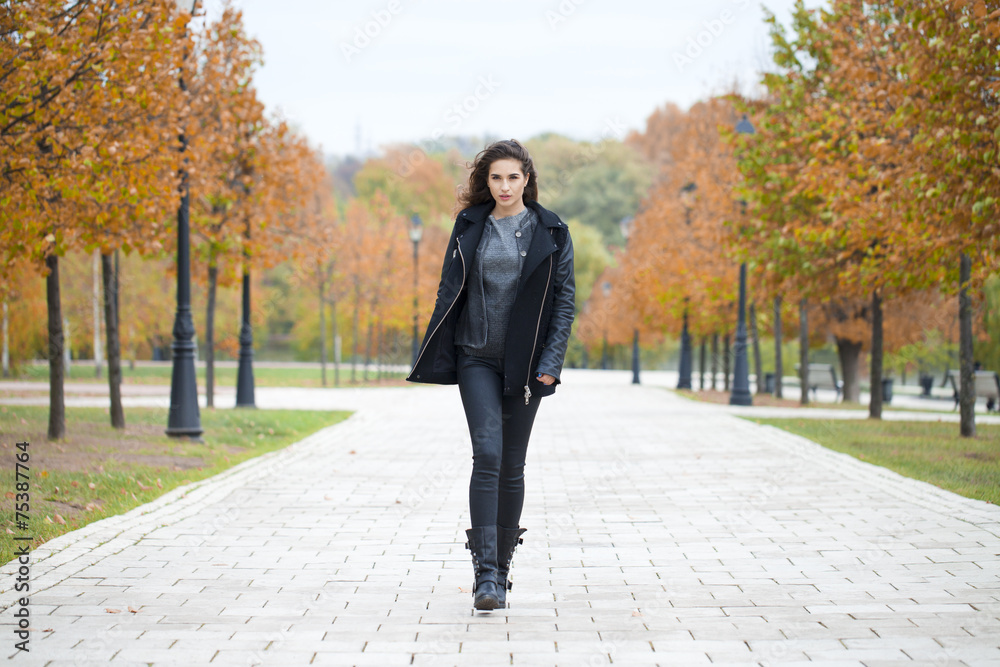 Happy woman in black coat walking autumn street Happy woman in black coat walking autumn street