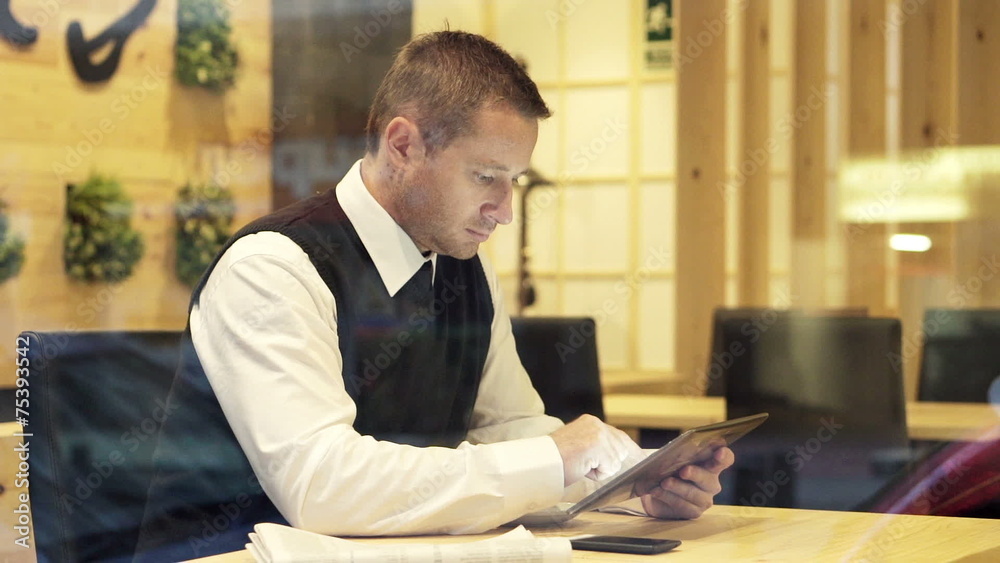 businessman working on tablet computer sitting in cafe businessman working on tablet computer sitting in cafe