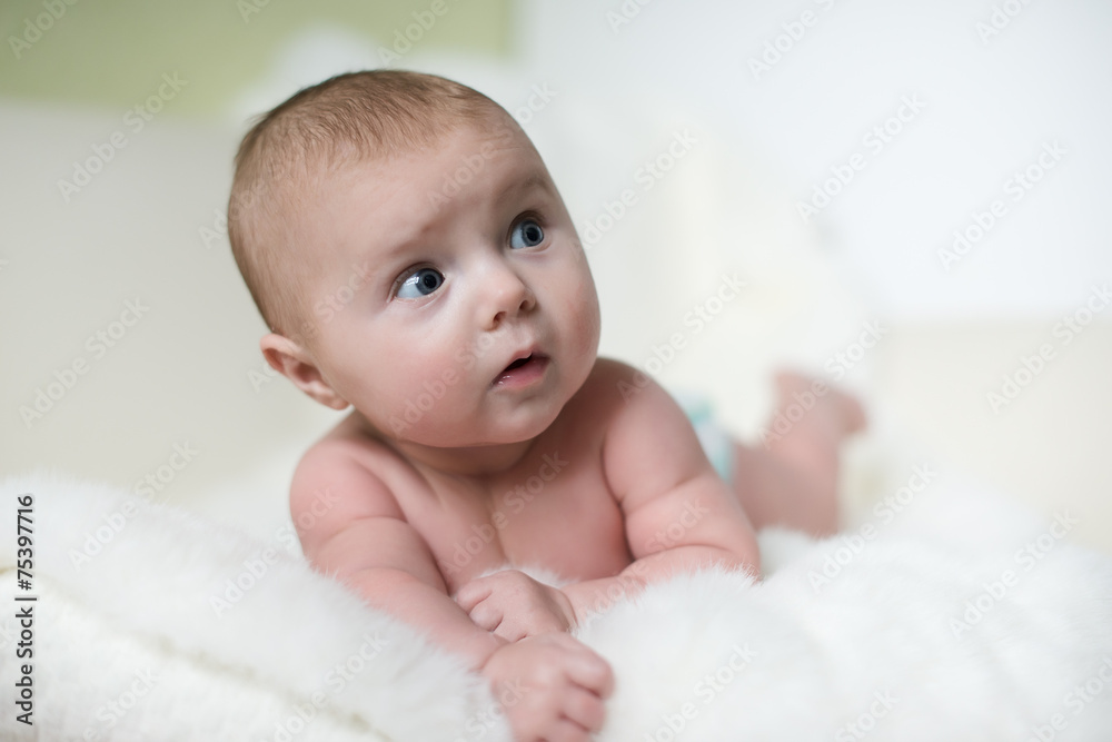The surprised baby lying on white towel The surprised baby lying on white towel