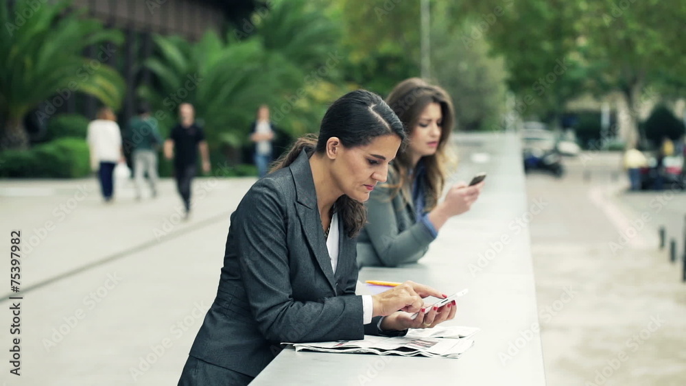 Young businesswoman texting, sending sms on smartphone in the ci Young businesswoman texting, sending sms on smartphone in the ci
