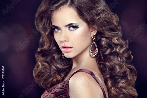 Wavy hair. Attractive girl with makeup. Jewelry Earring. Express