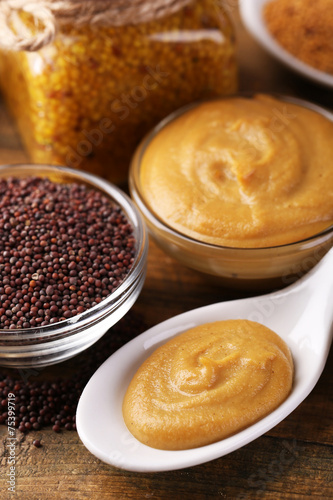 Mustard seeds, powder and sauce in spoons  and bowls