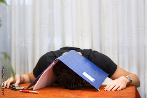 Tired, exhausted or despondent young man with a folder over his photo