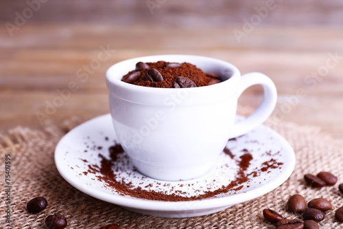 Mug of coffee beans and ground coffee