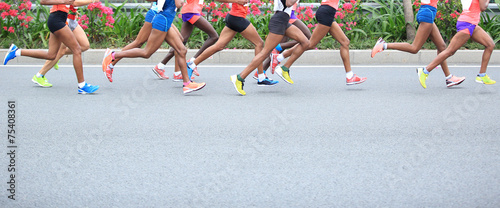 Marathon running race, people feet on city road 