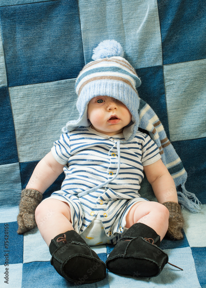 Cute baby boy wearing of warm knitted hat , gloves , Ugg boots Stock Photo  | Adobe Stock