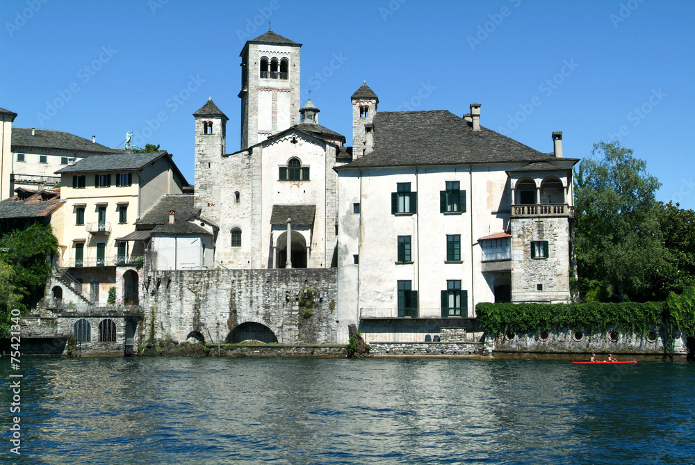 People rowing on a canoe in front of San Giulio island