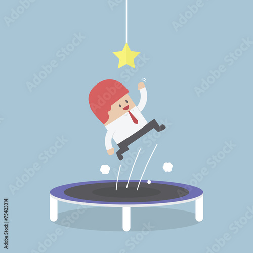 Businessman trying to catch the star by jumping on trampoline