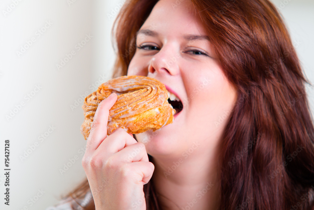Happy woman eating donuts at the table Happy woman eating donuts at the table