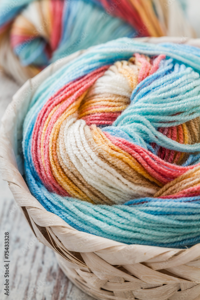 Colorful Soft woolen yarns in a Basket on wooden background Colorful Soft woolen yarns in a Basket on wooden background