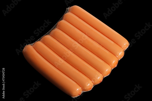 sausages in a shrink bag on the black background