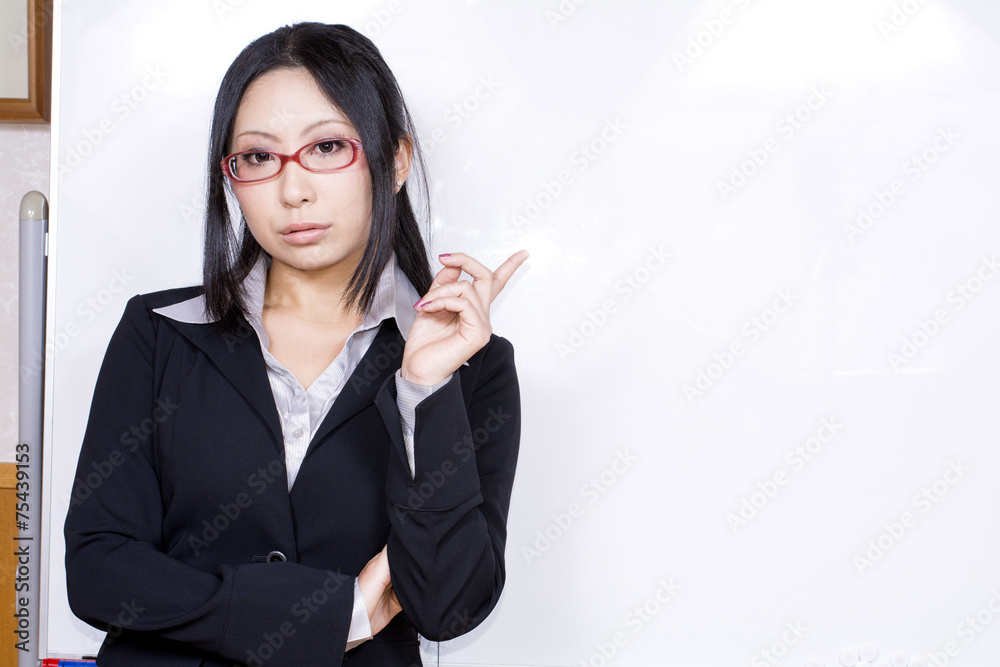ホワイトボードの前で指差すスーツ姿の女性 ホワイトボードの前で指差すスーツ姿の女性