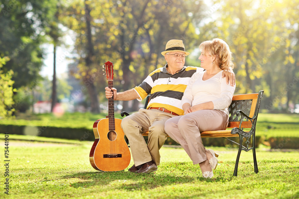 Mature man sitting with his wife in park Mature man sitting with his wife in park