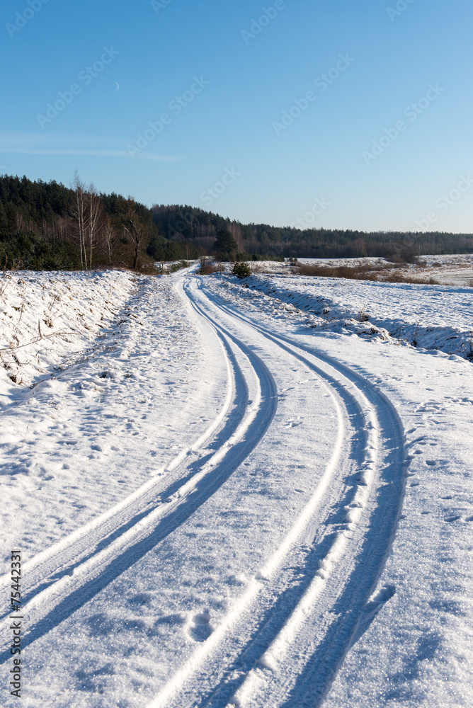 snowy winter road with tire markings