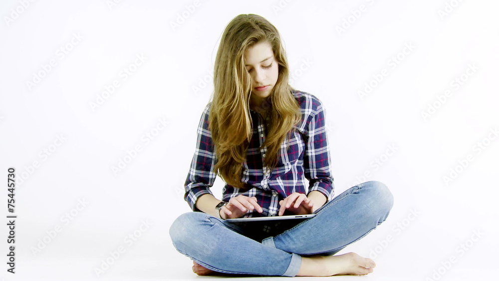Blond teenager girl with long hair writing with tablet Blond teenager girl with long hair writing with tablet