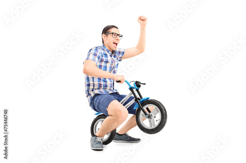 Crazy young man riding a small bike