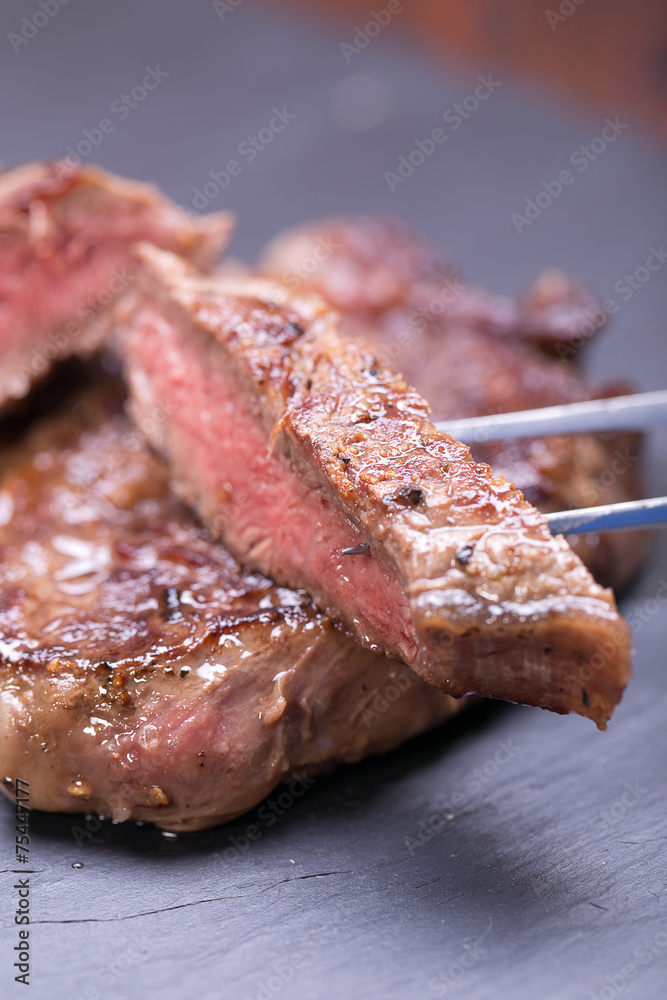fresh, grilled beef steak on wooden background 