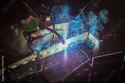 Flash of smoke and colorful sparks during welding