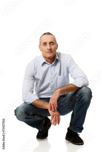 Canvastavla Happy handsome mature man squatting