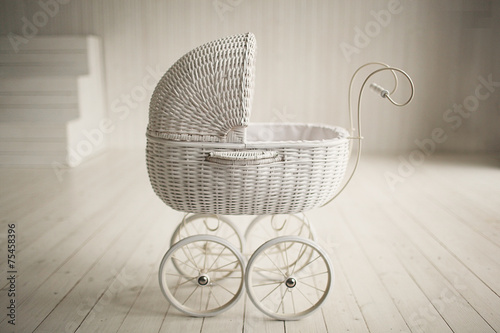 Beautiful old fashioned white pram in white room photo