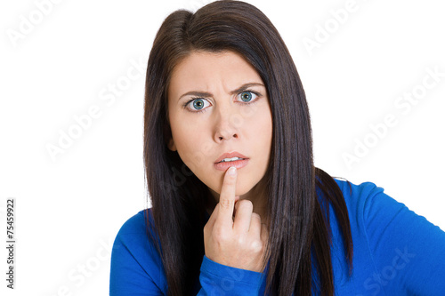 Young woman, finger on lips, looking confused surprised 