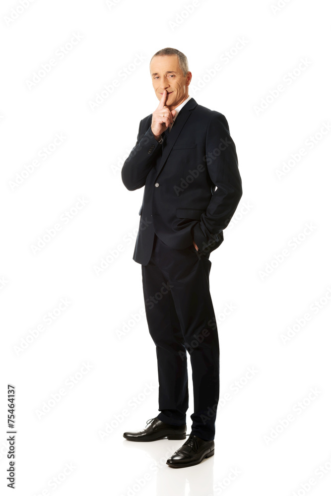Full length businessman gesturing silent sign