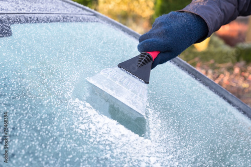 Hand scratching ice from car window