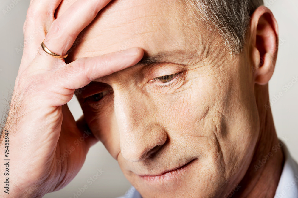 Fototapeta premium Portrait of depressed mature man touching his head