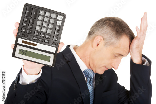 Depressed businessman holding a calculator