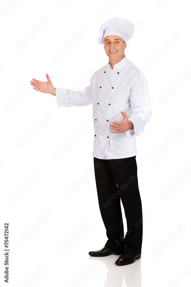Mature chef holding empty space in hands Mature chef holding empty space in hands