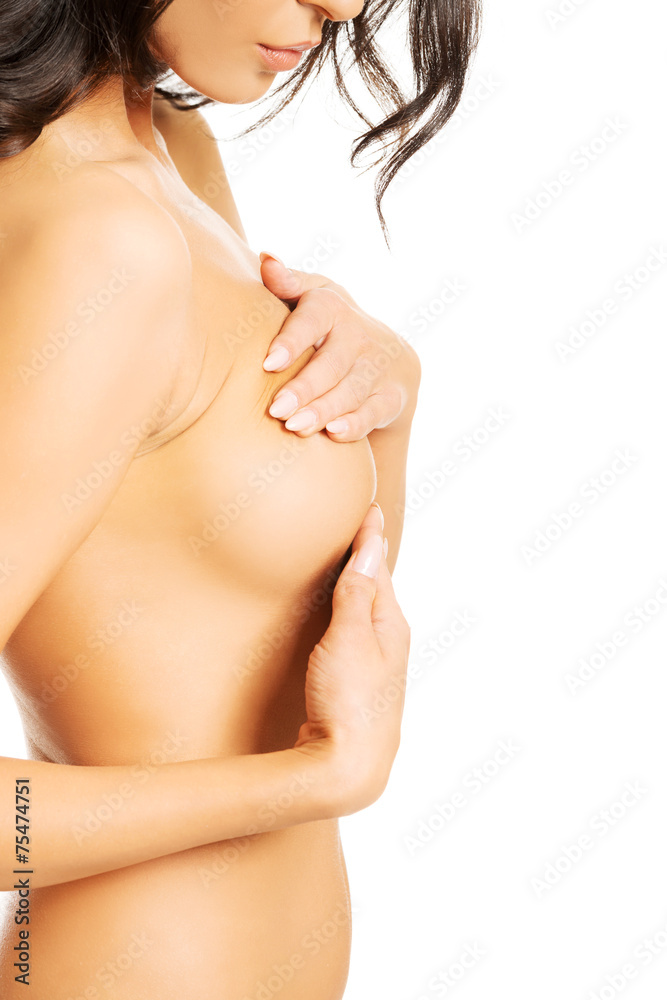 Obraz premium Side view of nude woman examining her breast