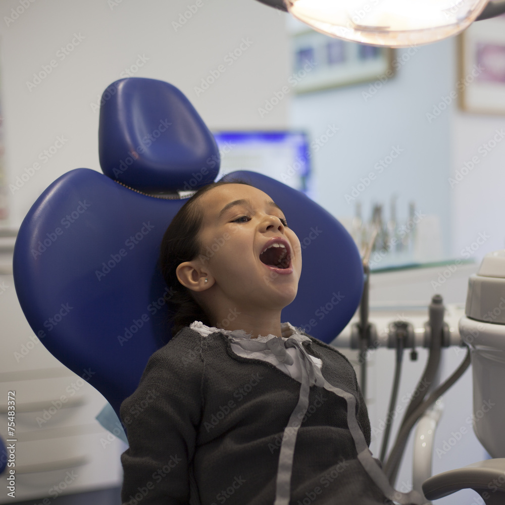 Niña abriendo la boca en consulta de dentista