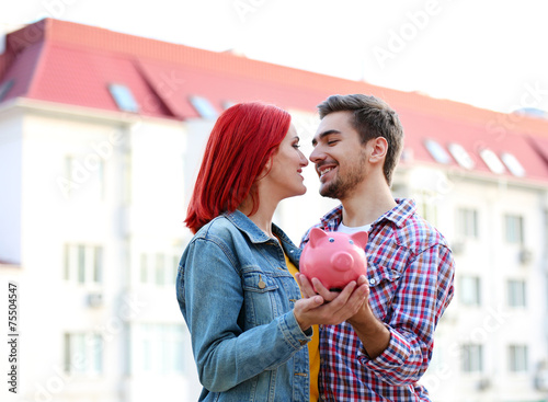 Loving couple with piggy ba...