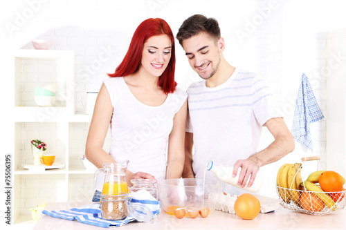 Happy couple preparing dough baking in kitchen