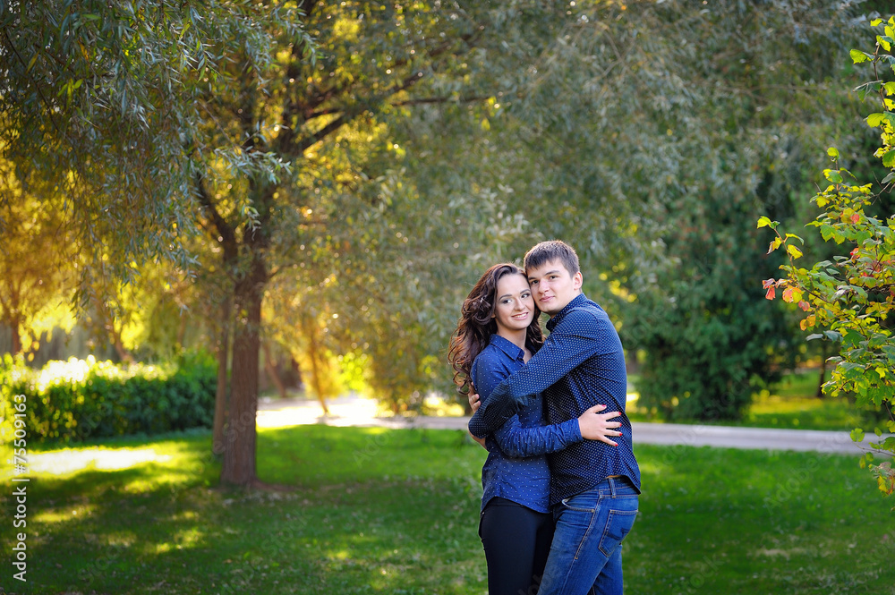 Loving couple in the autumn park sitting on a bench