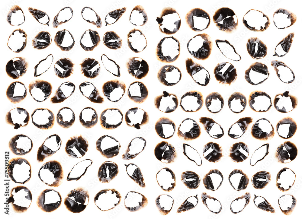 Collection of burnt holes in a piece of paper isolated on white