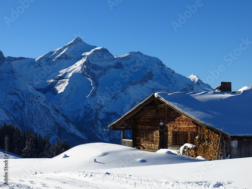 Snow covered Oldenhorn and facade of a farmhouse