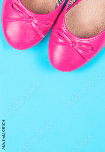 Part of pink shoes on blue background