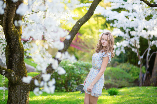 Beautiful girl in cherry blossom garden