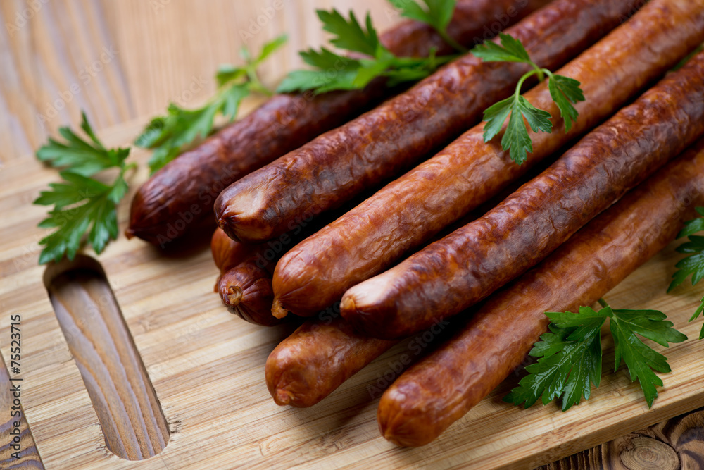 Close-up of smoked sausages with fresh parsley, horizontal shot