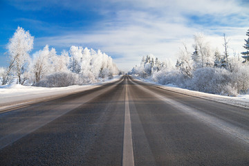 winter rural  landscape with the road the forest and the blue sk