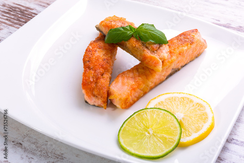 Salmon steak with lemon and lime on the plate