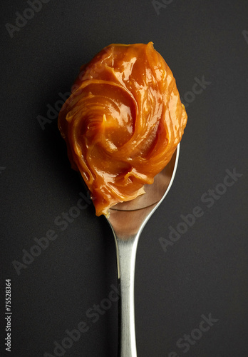 Spoon of melted caramel cream