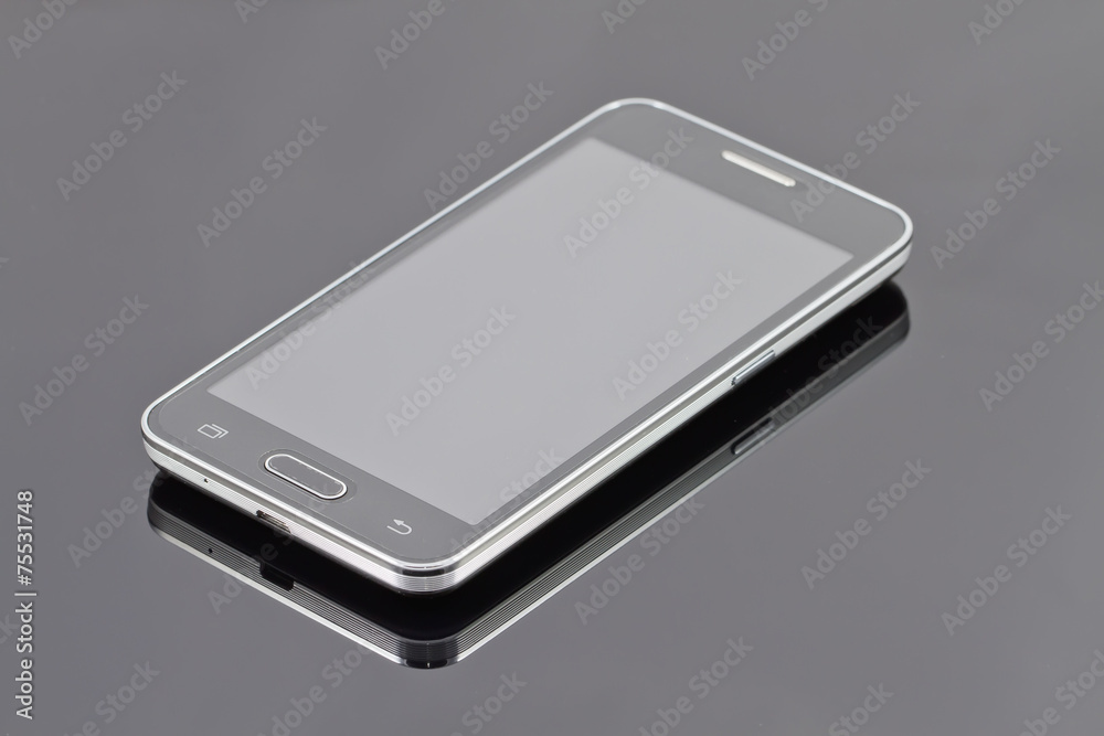 new smartphone is lying on a black reflective surface new smartphone is lying on a black reflective surface